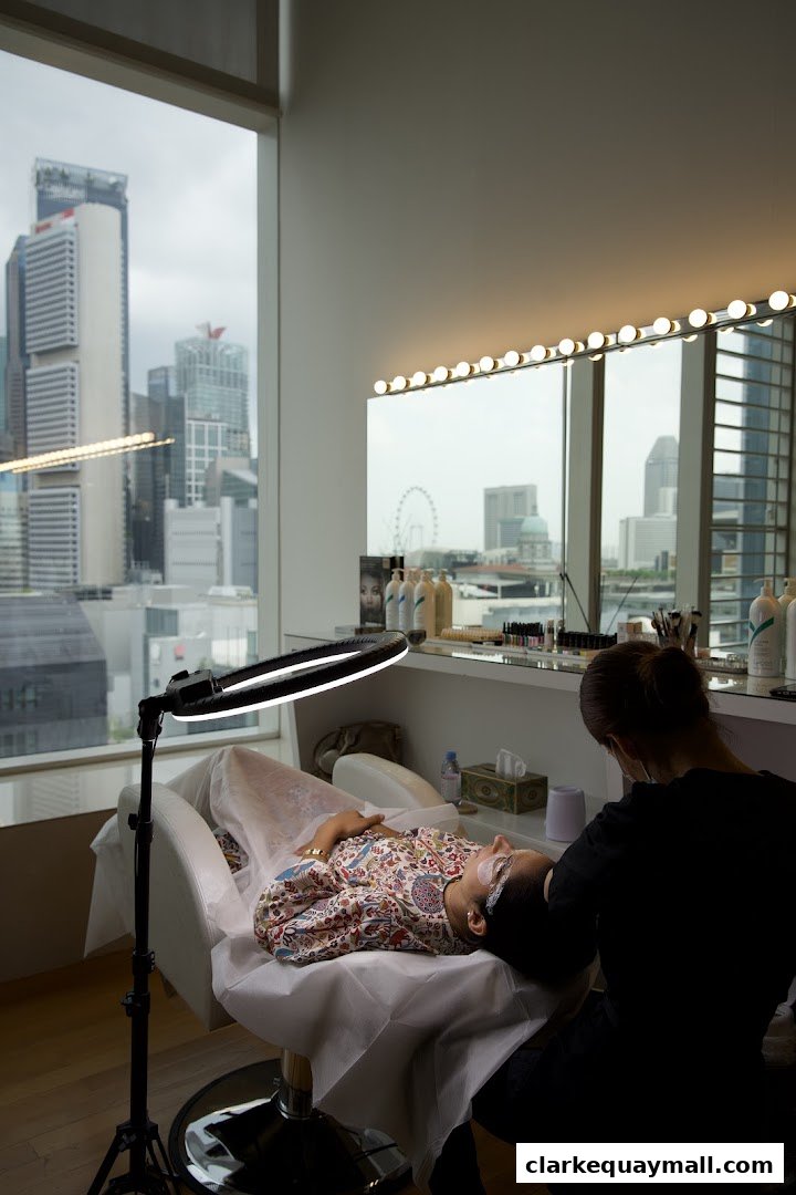 A client receives beauty treatment in a well-lit room with a city view.