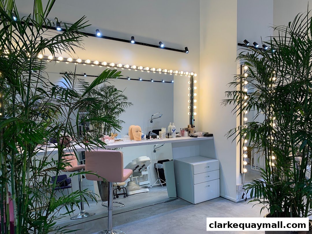 Interior of a beauty academy with makeup stations, plants, and training mannequins.