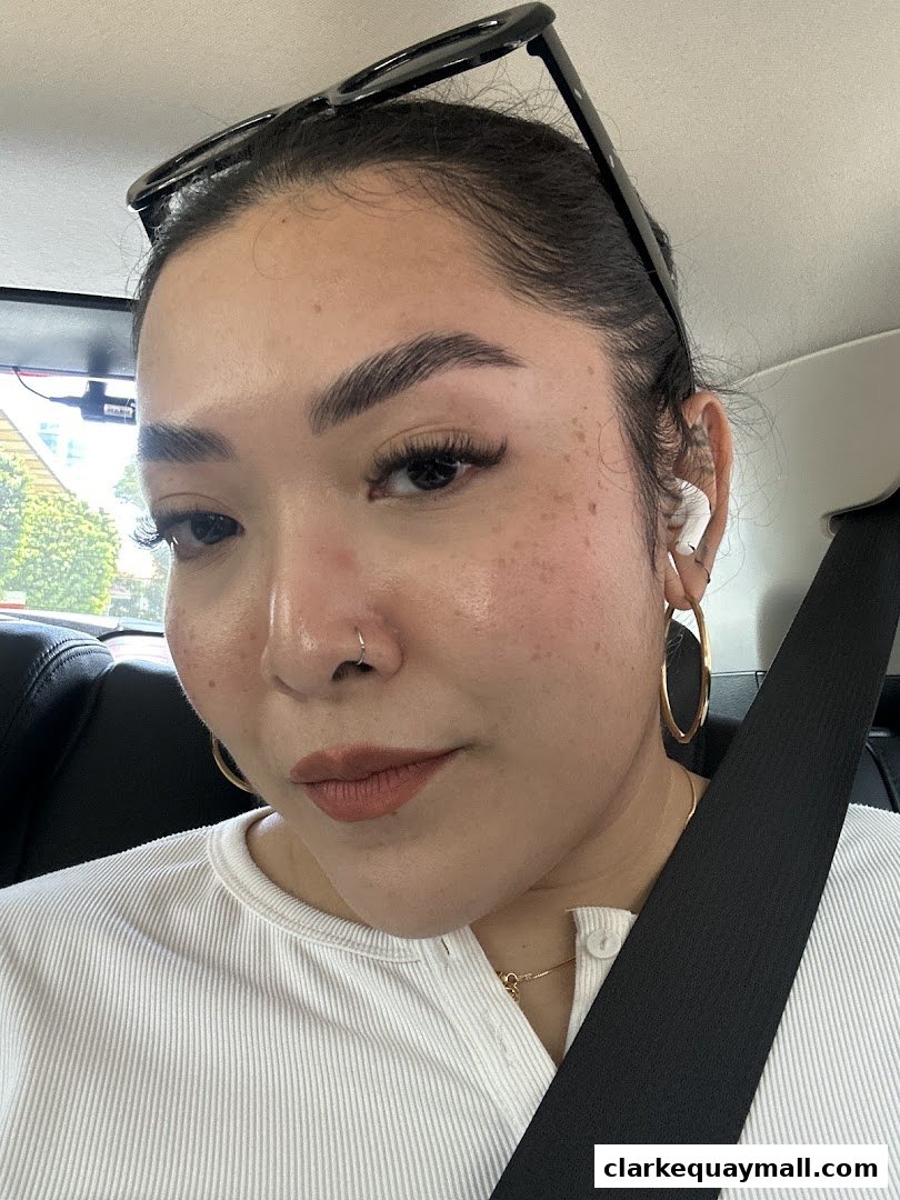 A close-up portrait of a woman with well-defined eyebrows, lashes, and subtle freckles.