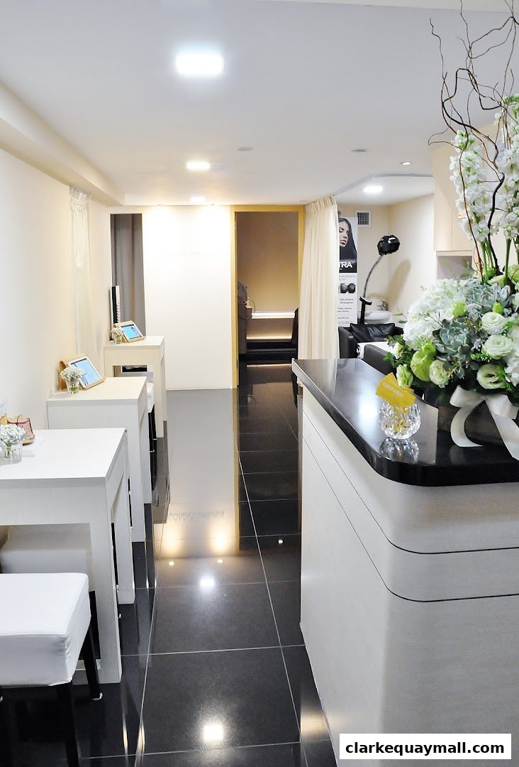 Interior view of a clean and modern aesthetics clinic with a reception desk and treatment areas.