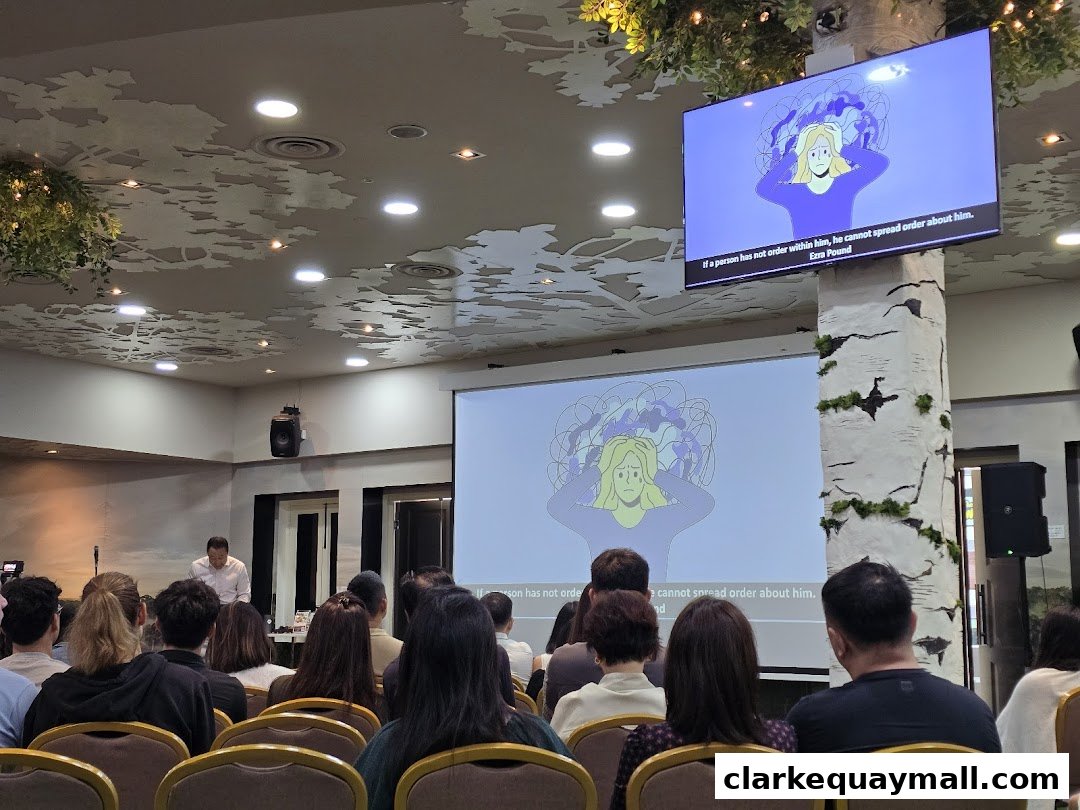 An audience watches a presentation with animated graphics and text on a screen.