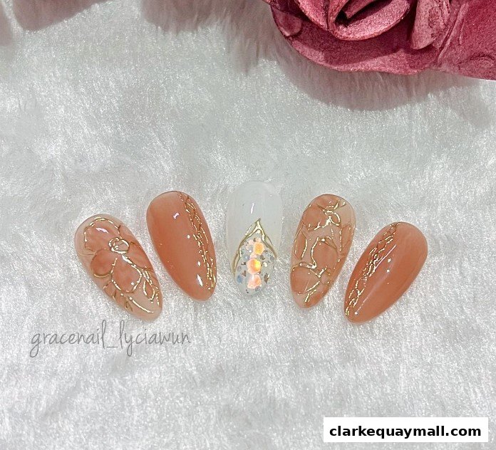 A set of five beautifully designed artificial nails with floral and gold accents.