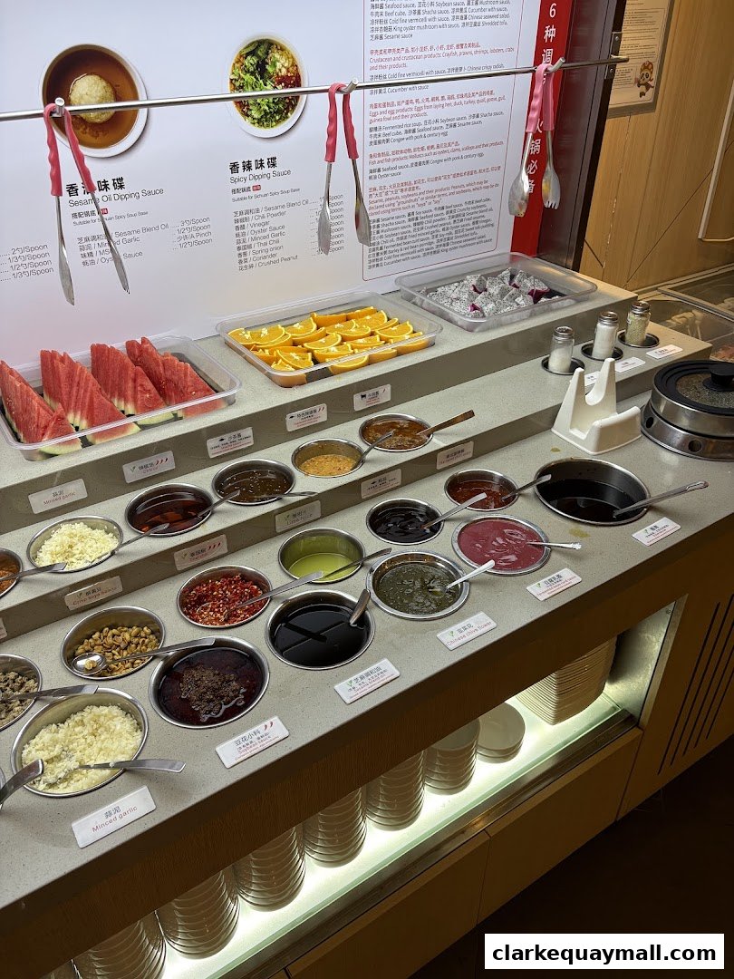 A display of various dipping sauces and fresh fruits for hot pot.