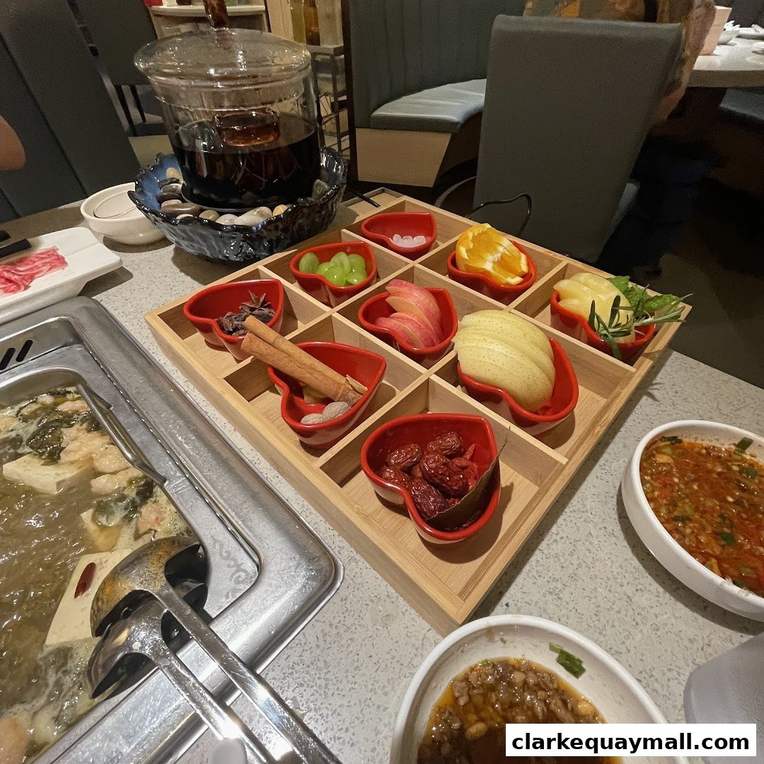 A table setting at Haidilao Hot Pot with various ingredients and dipping sauces.