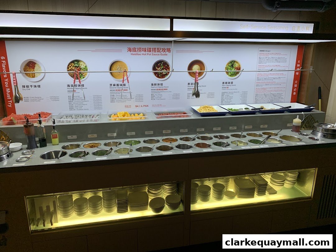 A self-service seasoning bar at Haidilao Hot Pot with various ingredients and sauce guides.