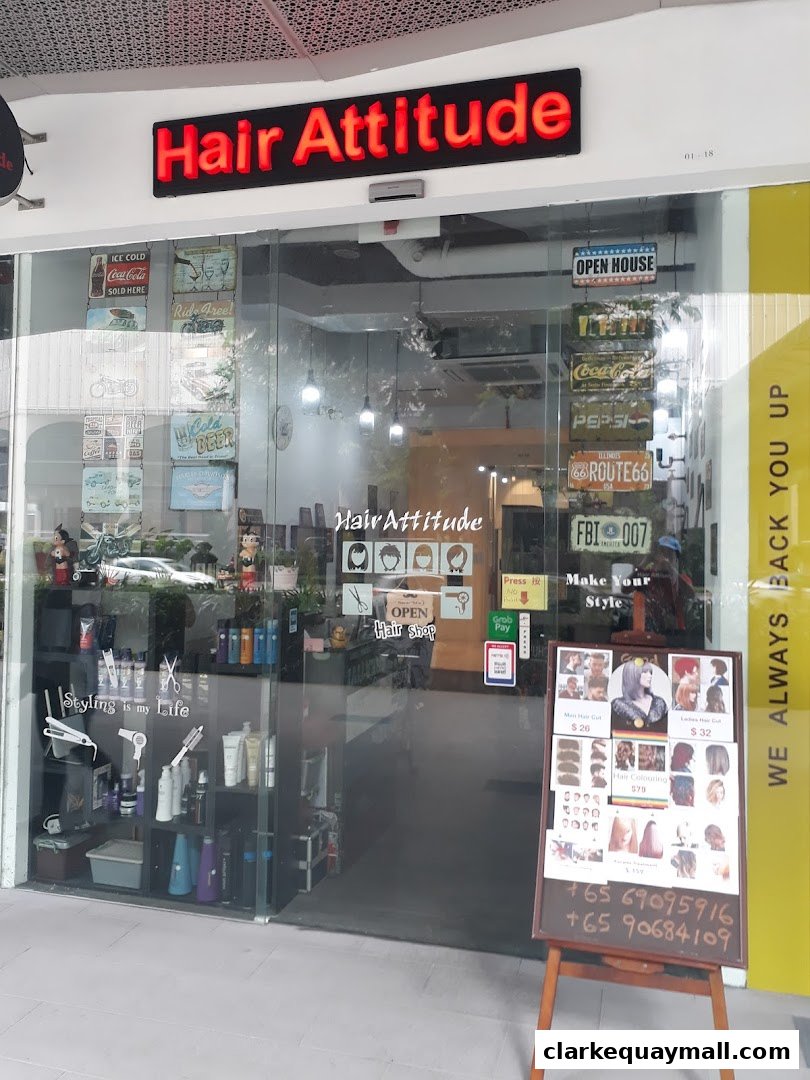 The storefront of Hair Attitude, a hair salon, with a display of hairstyles and prices.