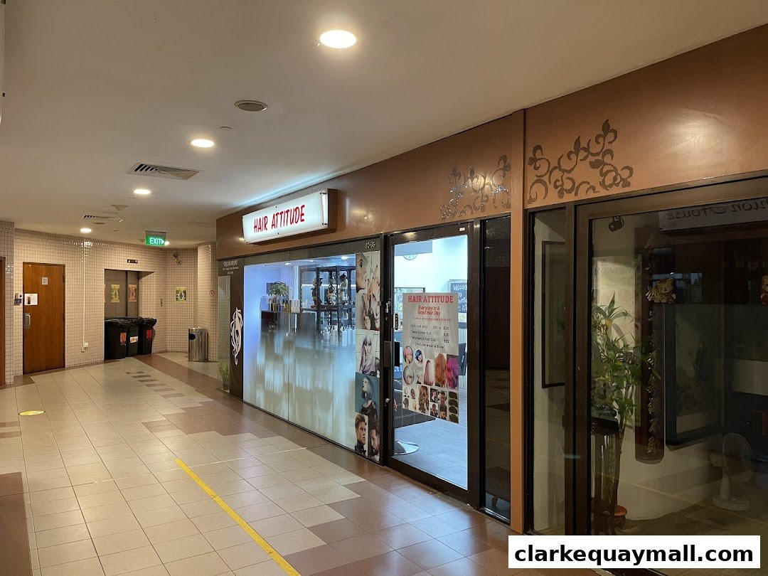 The exterior of the Hair Attitude salon, showcasing its entrance and display of hairstyles.