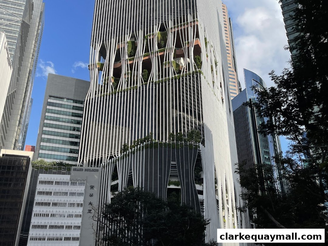 Modern skyscrapers with unique architectural designs and lush greenery against a blue sky.