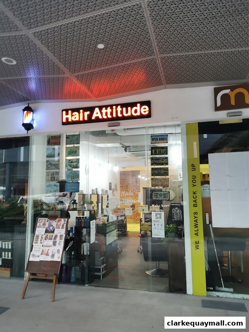 The entrance of Hair Attitude salon, featuring a barber pole, neon sign, and interior views.