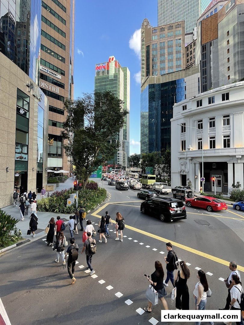 People crossing a busy street in a modern city with tall buildings.