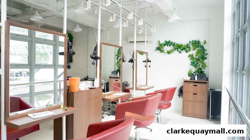 Interior view of a modern hair salon with styling stations, mirrors, and red chairs.