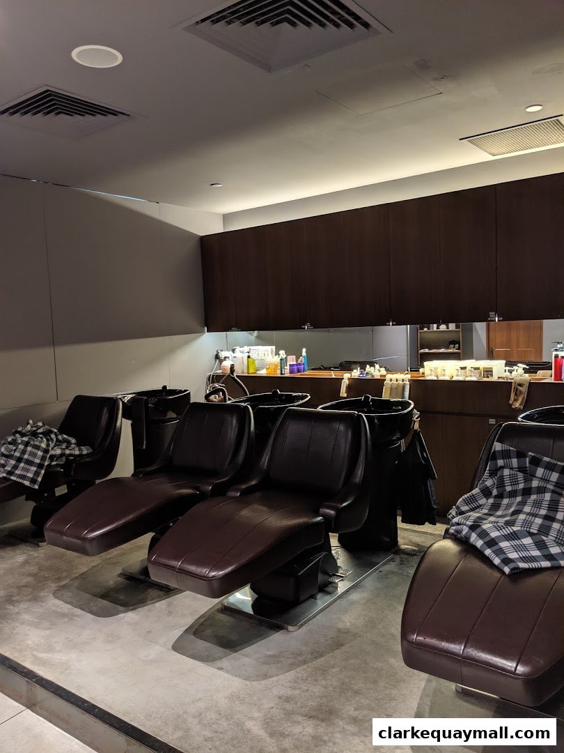 Interior shot of a hair salon with multiple reclining shampoo chairs and cabinets.