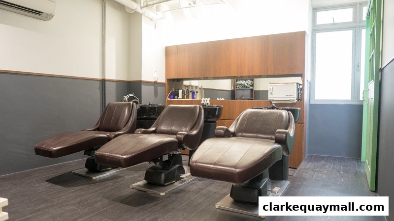 Interior of a hair salon with three reclining chairs and wash basins.