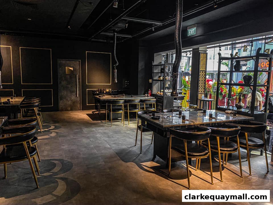 Interior view of Hanjip Korean Grill House with modern black and gold decor and dining tables.