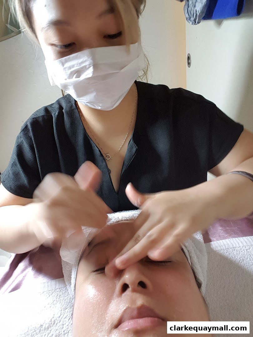 Aesthetician performing a facial massage on a client.