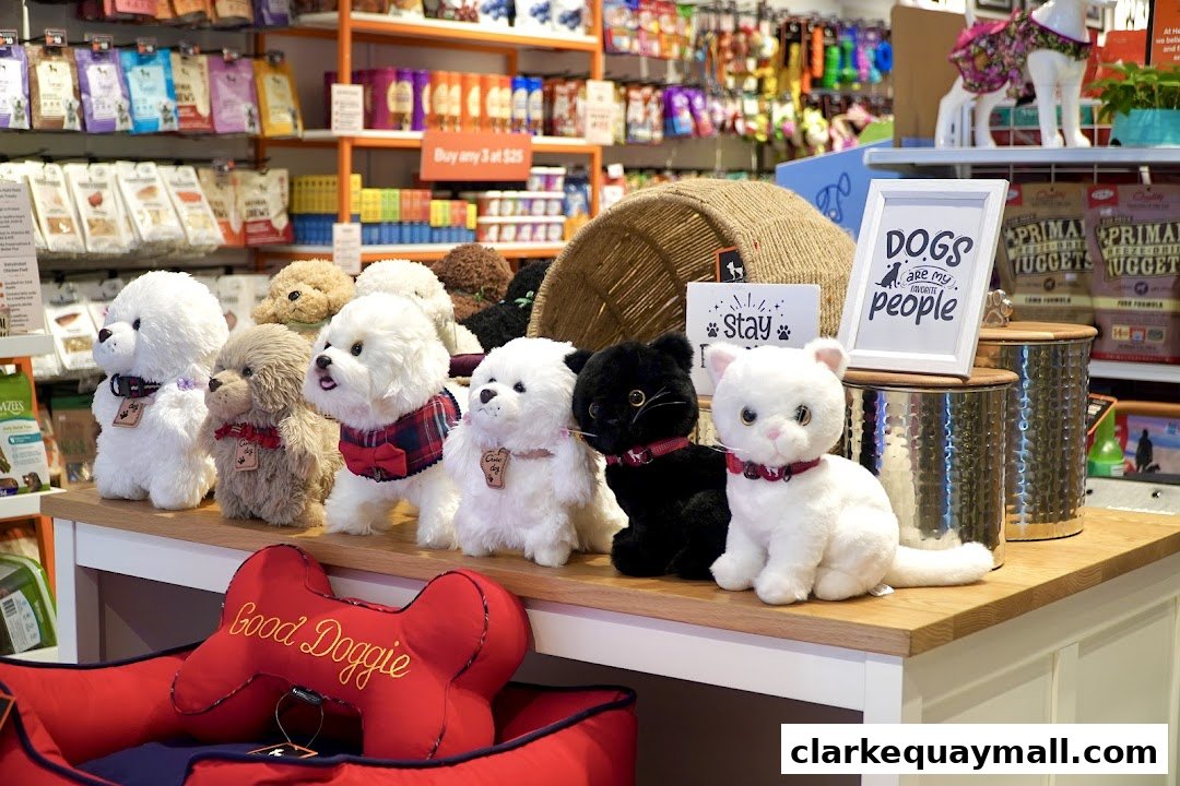 Plush dogs and cats displayed with pet supplies and accessories in a retail store.