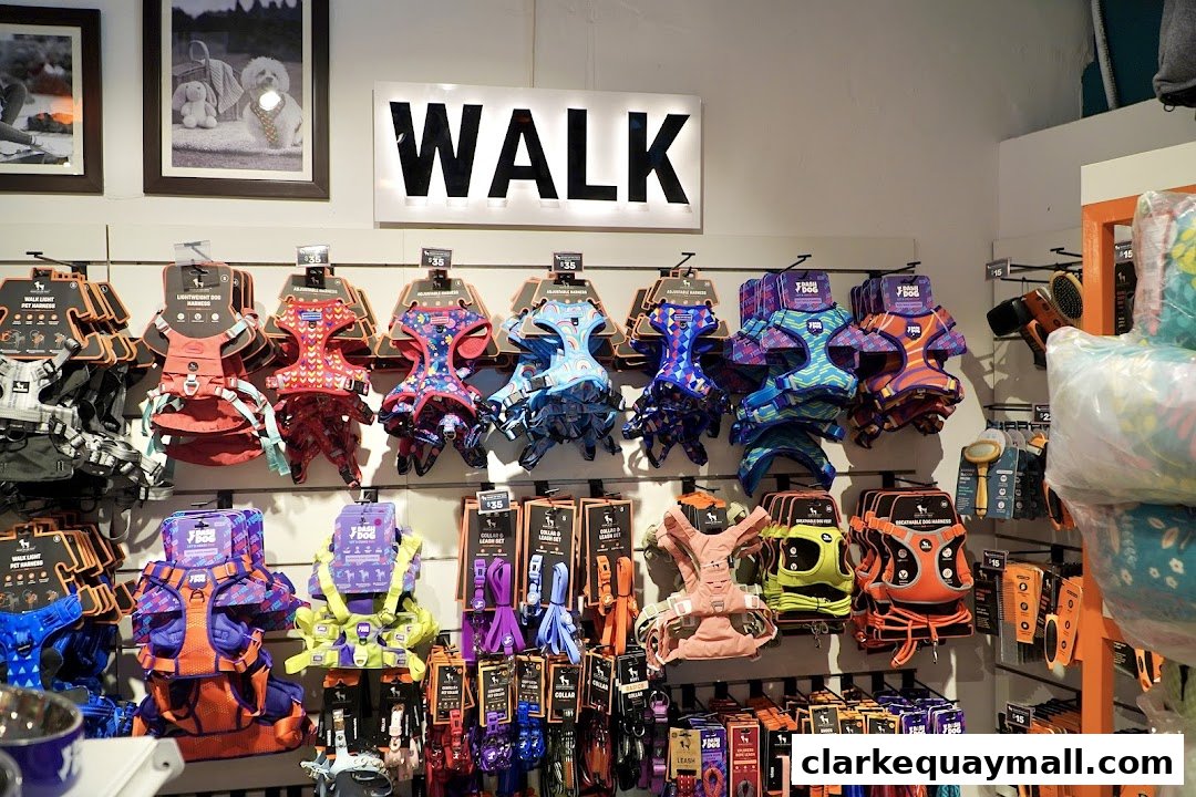 A wall display of colorful dog harnesses and leashes at Heads Up For Tails.