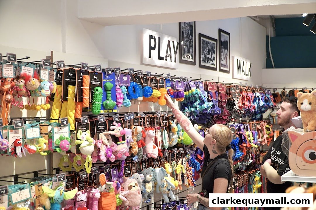 Customers browsing a wide selection of colorful pet toys and accessories in a well-lit store.