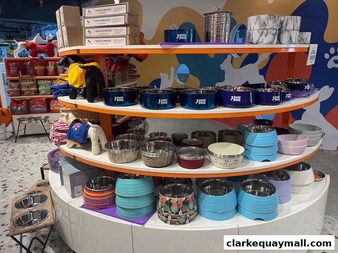 A retail display featuring various pet bowls and accessories, including dog toys and food.