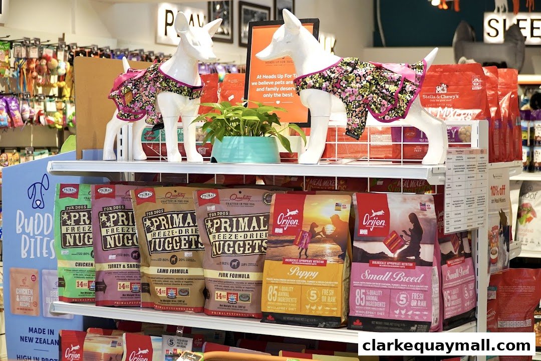 A retail display featuring dog food and accessories, with mannequins dressed in dog outfits.