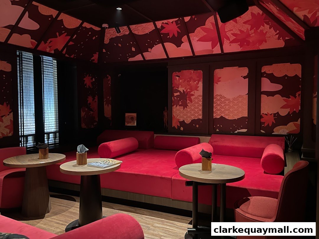 Luxurious red seating and tables in a dimly lit lounge with Japanese-inspired decor.
