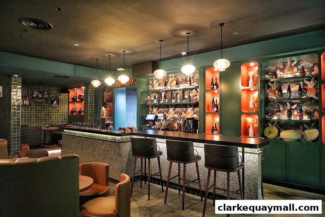 Interior of a stylish cocktail lounge with a long bar, seating, and shelves stocked with bottles.