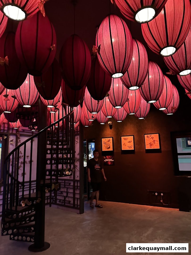 Interior of a cocktail lounge with numerous red lanterns and a spiral staircase.