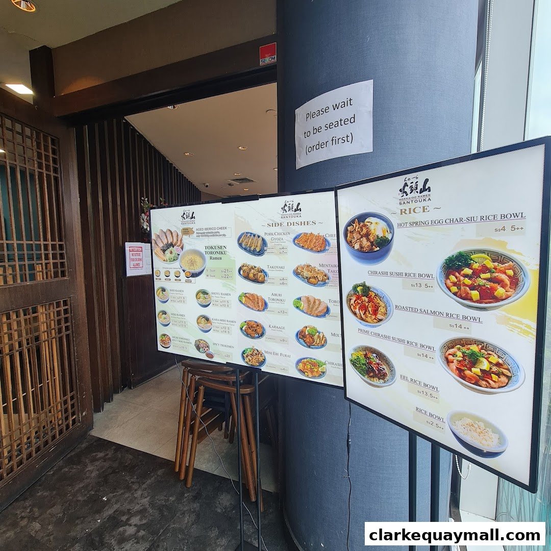 A menu board displaying various ramen, side dishes, and rice bowls from Hokkaido Ramen Santouka.