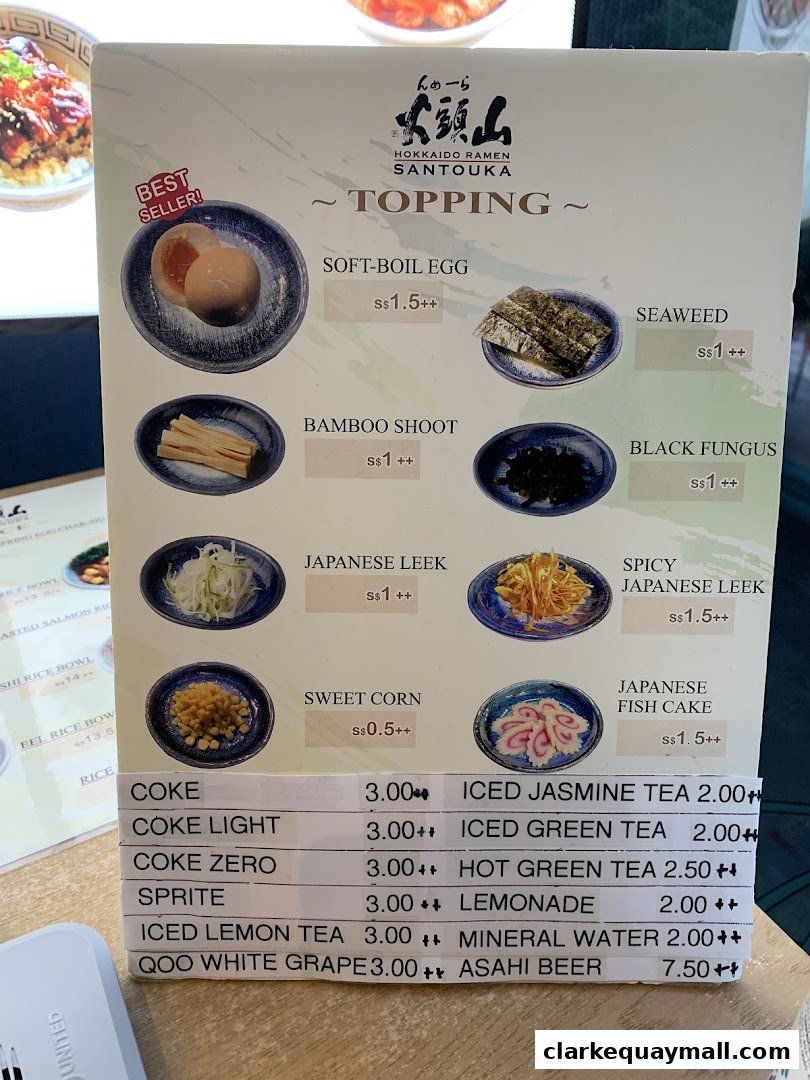 A menu from Hokkaido Ramen Santouka featuring toppings and drinks with prices.