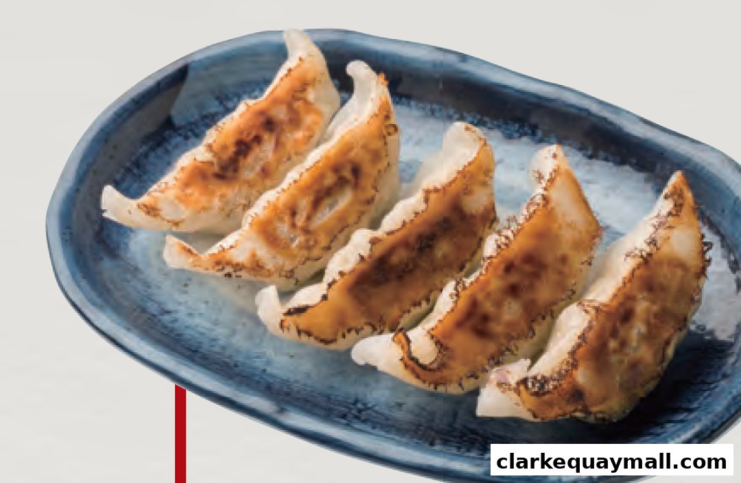 A plate of golden-brown pan-fried gyoza dumplings on a blue textured plate.