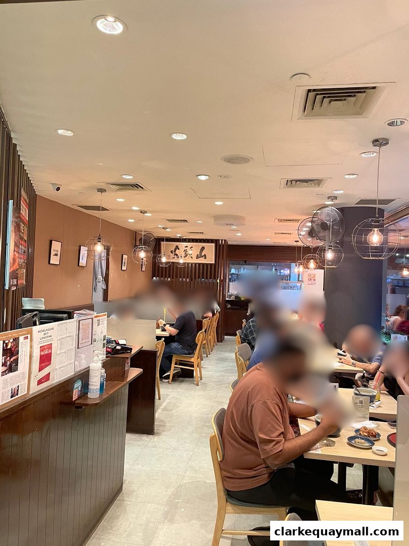Interior view of Hokkaido Ramen Santouka with diners seated at tables.