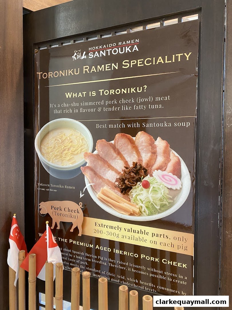 A sign advertising Hokkaido Ramen Santouka's Toroniku Ramen Specialty with a picture of the dish.