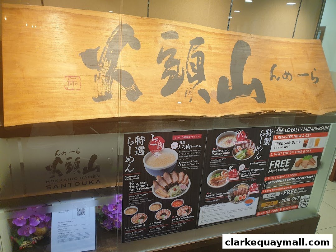 Hokkaido Ramen Santouka shop front with a large wooden sign and menu displays.