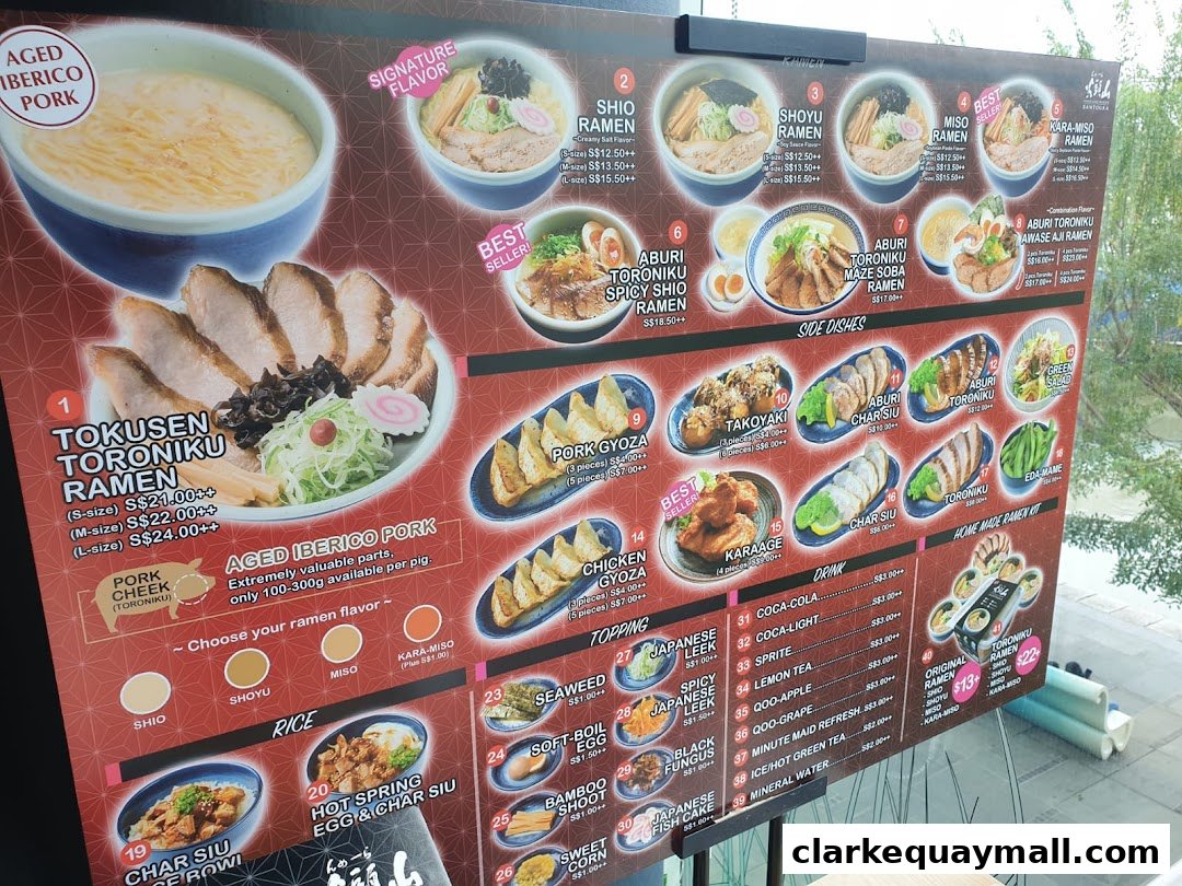 A menu board displaying various ramen dishes, side dishes, drinks, and toppings with prices.