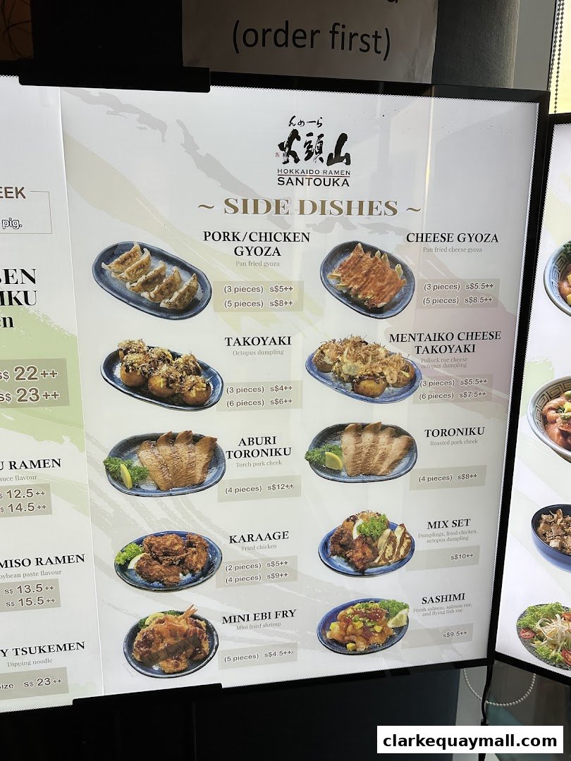 A menu board for Hokkaido Ramen Santouka, showcasing various side dishes with images and prices.