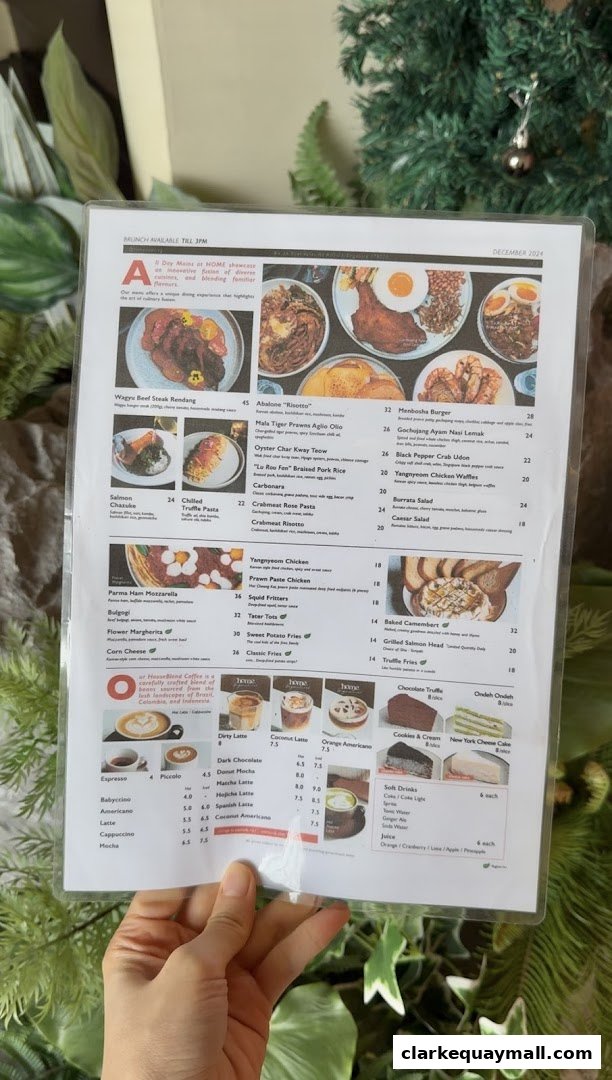 A menu from Home Dawn Cafe featuring various dishes and drinks, held by a person.