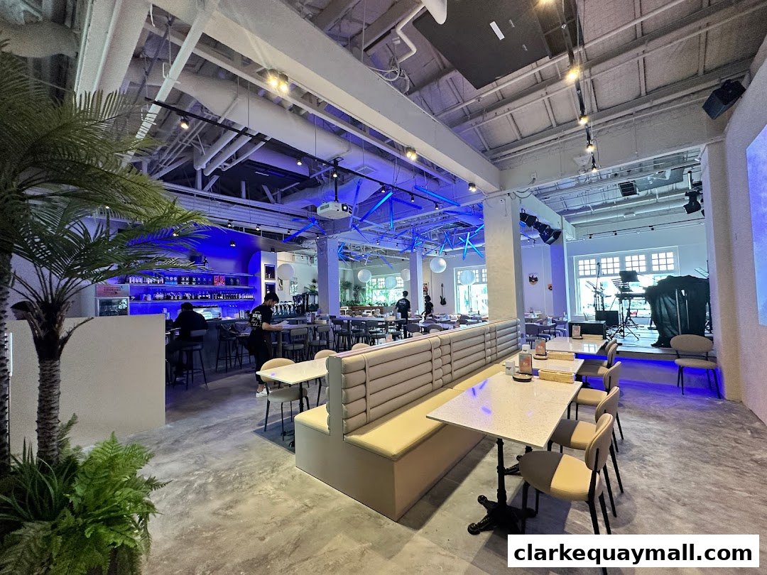 Interior view of a modern cafe with a bar, seating, and a stage area.