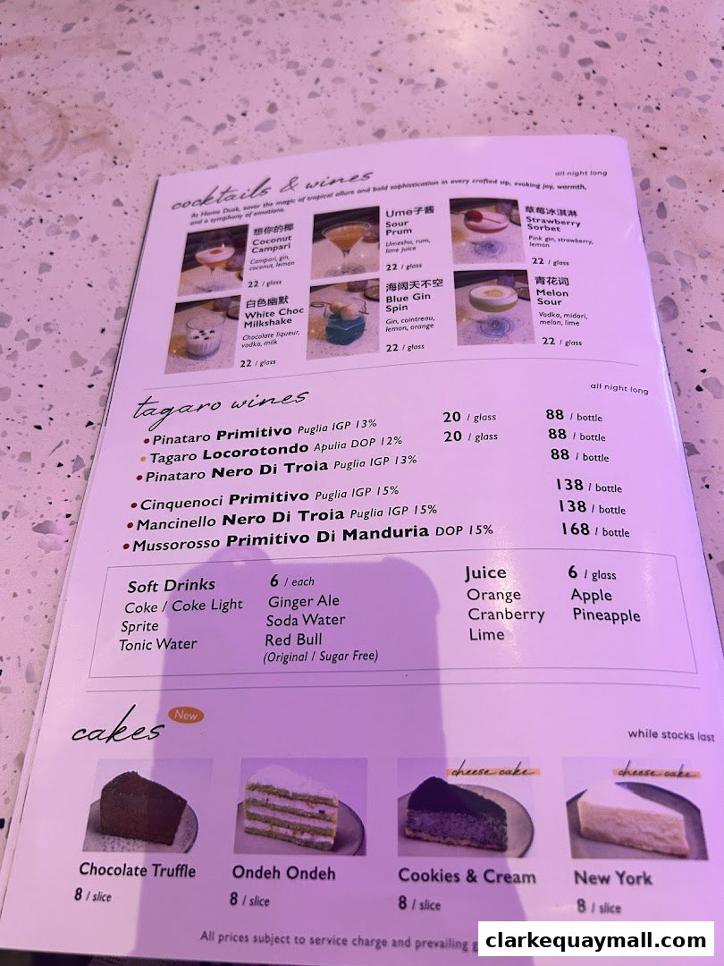 A menu featuring cocktails, wines, soft drinks, juices, and cakes with prices.