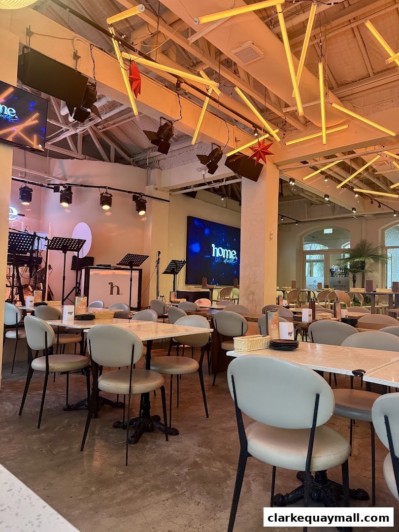 Interior of a live house with tables, chairs, stage, and screens.