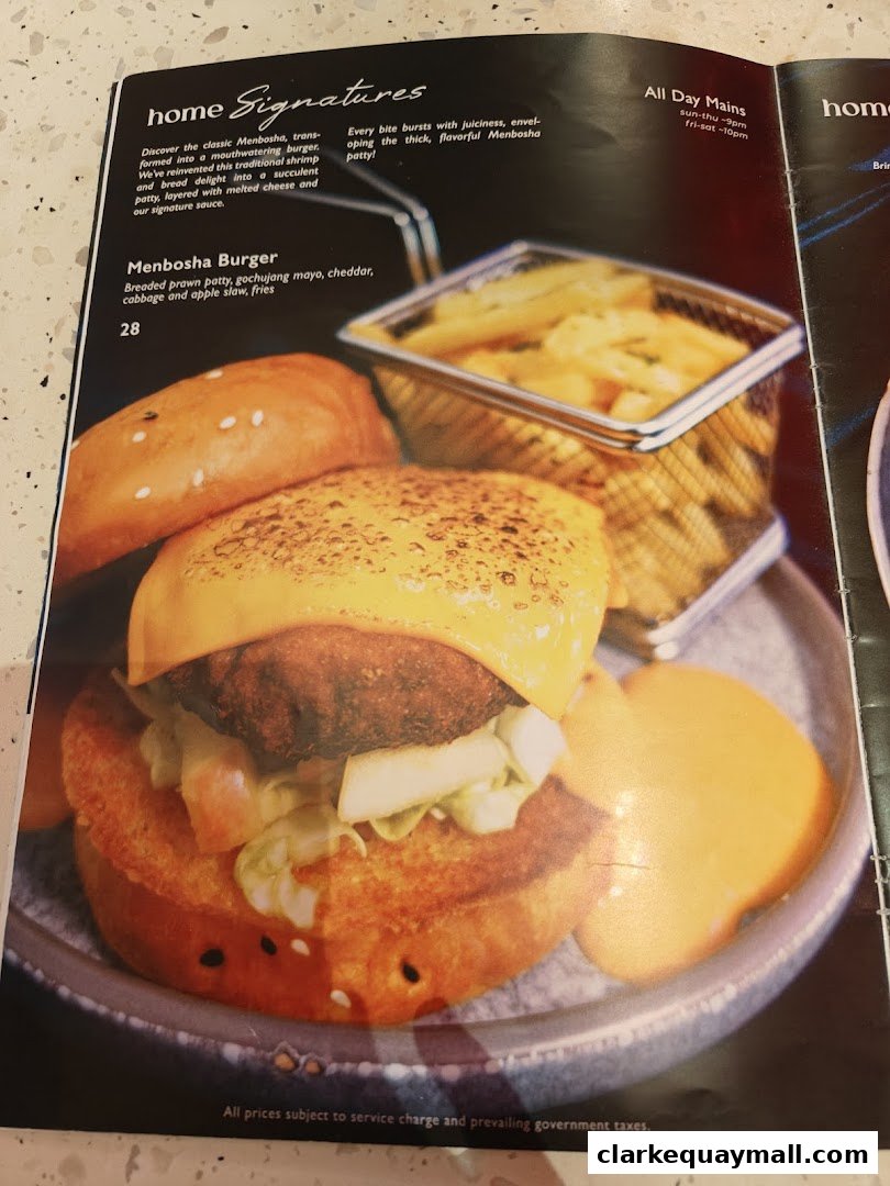 A close-up of a signature Menbosha Burger with fries and dipping sauce.