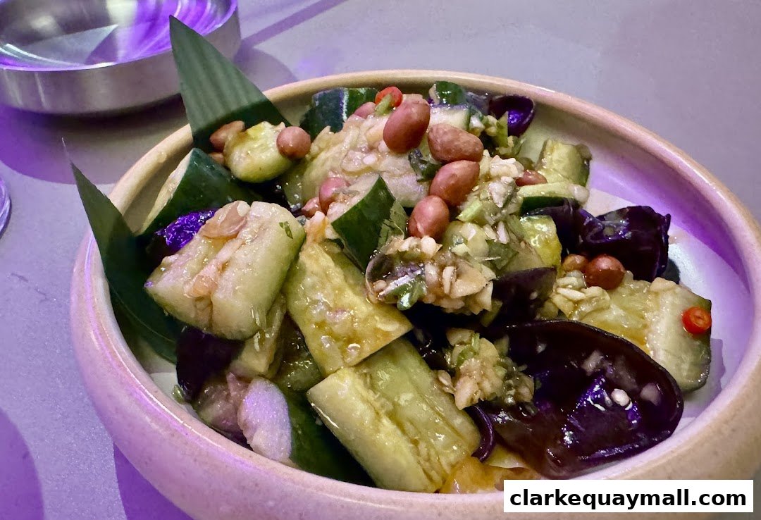 A close-up of a refreshing cucumber and eggplant salad with peanuts and chili.