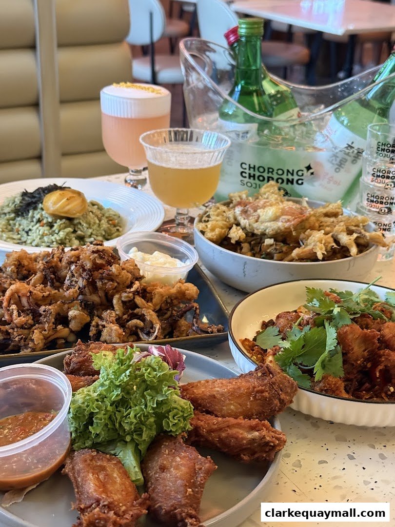 A table laden with various Korean fried dishes and drinks, including chicken wings and soju.