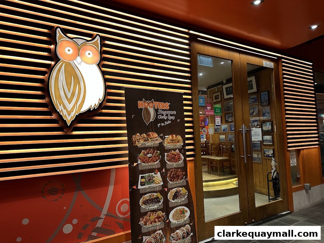 The entrance of Hooters restaurant with a menu board displaying food items.