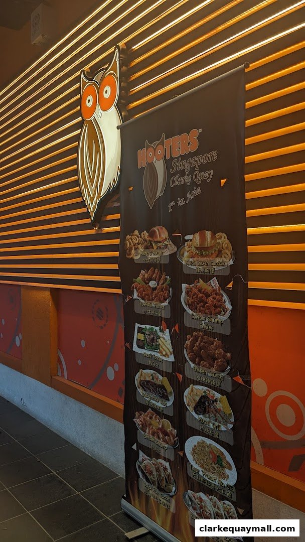 A Hooters Singapore Clarke Quay menu banner displaying various food items like burgers, wings, and ribs.
