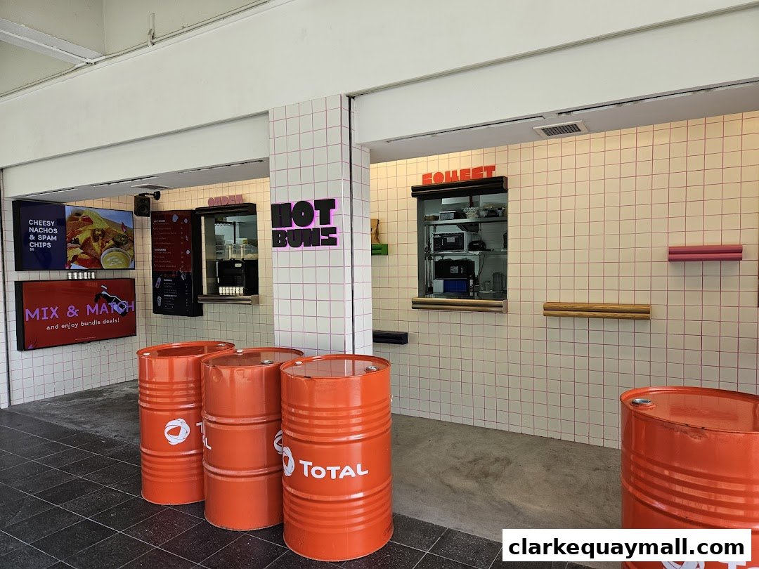 The exterior of a food stall named HOT BUNS with ordering and collection windows.
