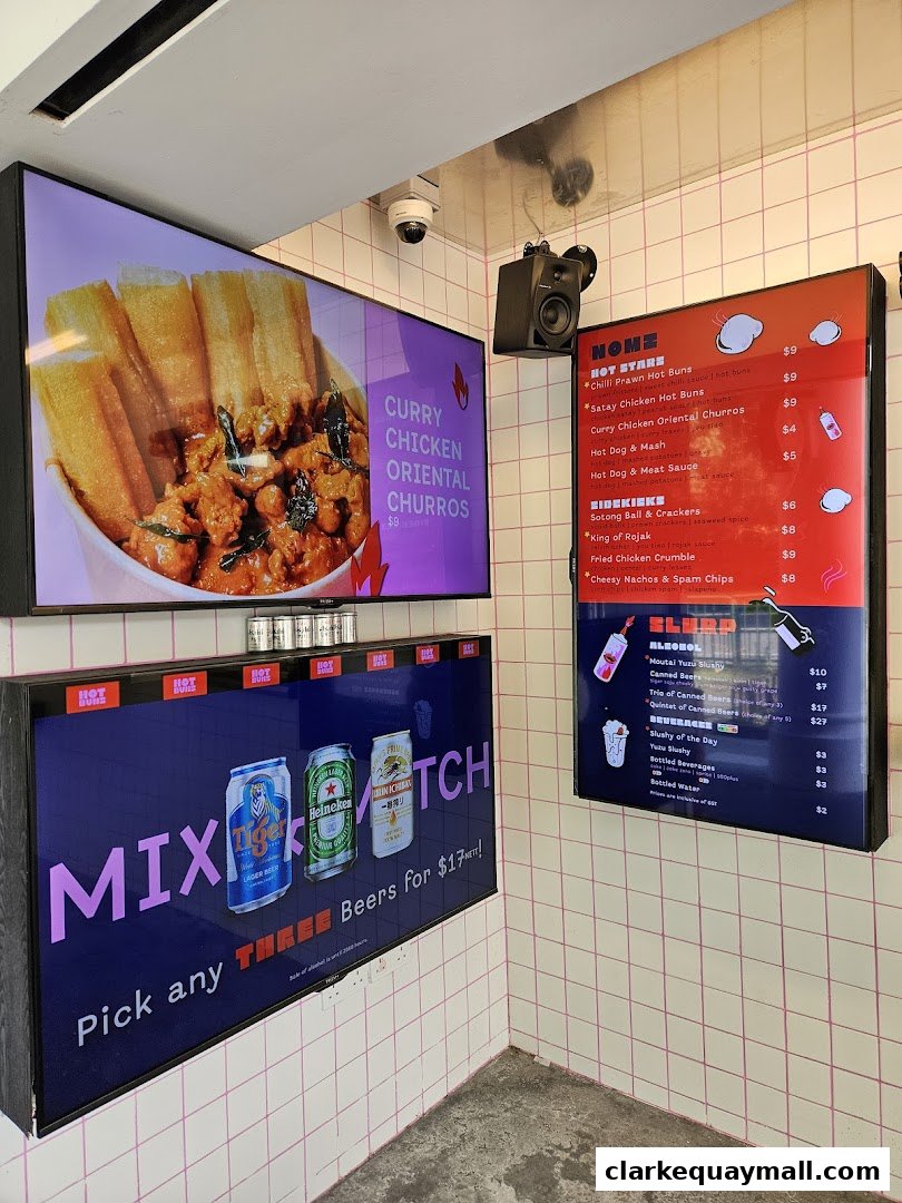 A shop interior with digital menus displaying food and drinks, including churros and beer.