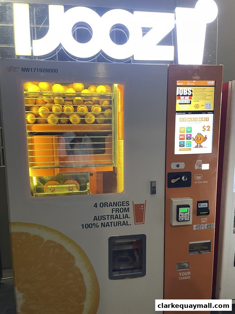 An iJooz fresh orange juice vending machine with oranges visible inside.