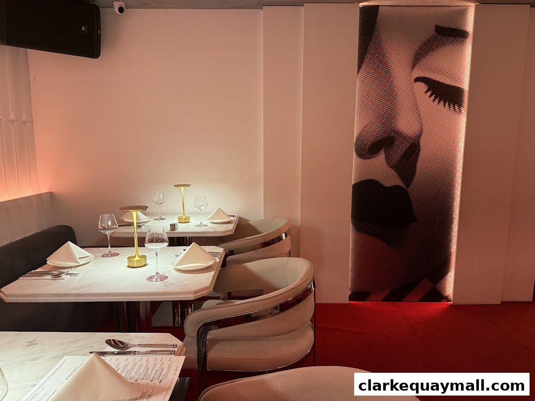 Elegant dining tables set with white napkins and wine glasses, illuminated by modern lamps.