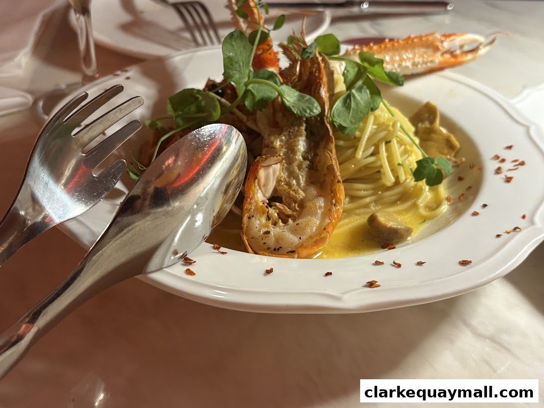 A close-up of a gourmet pasta dish with a large prawn and garnished with microgreens.