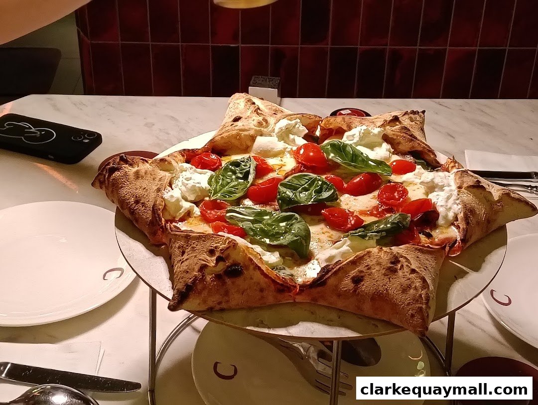 A star-shaped pizza with fresh tomatoes, basil, and creamy cheese on a marble table.